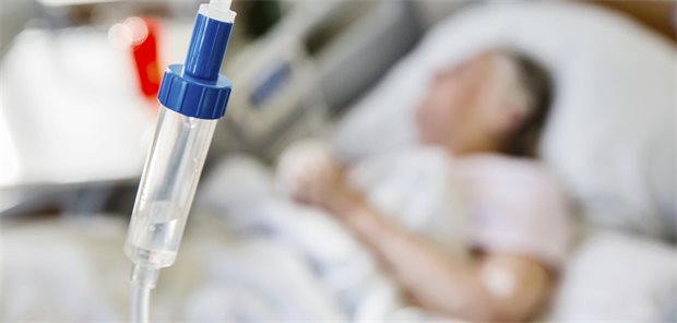 Tropf im Vordergrund, liegender Patient (unscharf)  im Hintergrund