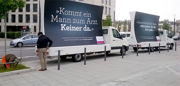 Vor dem Gebäude, in dem die KBV-VV stattfindet, stehen zwei Wagen mit der Botschaft: "Kommt ein Mann zum Arzt. Keiner da."