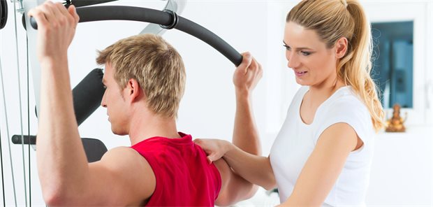 Mann mit einer Trainerin bei der Physio