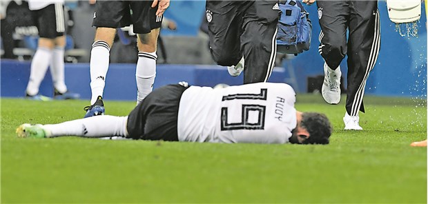 Profiteam im Einsatz für den Weltmeister WM-Spiel Deutschland - Schweden am Samstag: Teamarzt Hans Wilhelm Müller-Wohlfahrt (.) und Physio Wolfgang Bunz stürmen auf das Spielfeld, um den an der Nase schwer verletzten Sebastian Rudy zu versorgen.