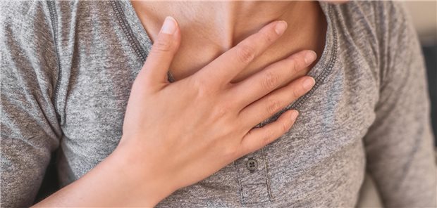 Frau fässt sich an die Brust