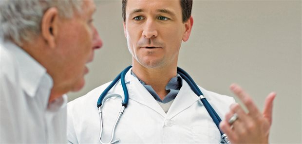 Ein Arzt mit umhängendem Stethoskop erläutert einem älteren männlichen Patienten einen Sachverhalt.