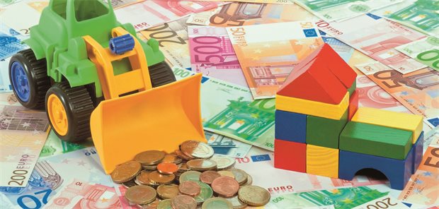 Das Foto zeigt einen Spielbagger sowie Euroscheine und -münzen.