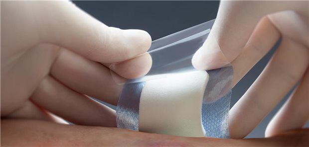 Arzt bringt Wundauflage an.