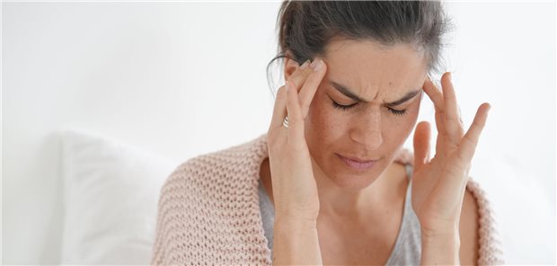 Eine Frau hält sich die Finger an die Schläfen.