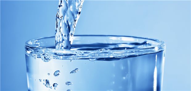 Geldquelle Trinkwasser – investieren ohne schlechtes Gewissen Ein recht volles Wasserglas, in das noch weiter Wasser eingeschenkt wird.