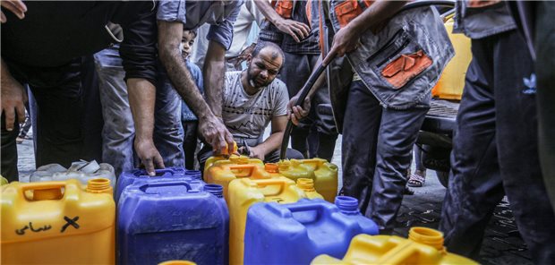 Unicef: Jedes dritte Kind weltweit leidet unter Wasserknappheit Menschen vor Kanistern.