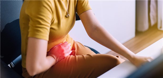 Nahaufnahme einer Frau mit starken Bauchschmerzen.