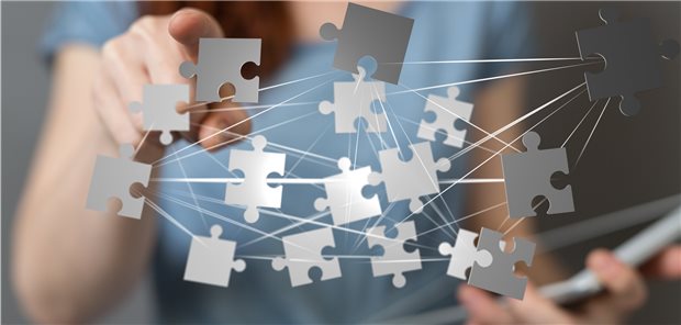 Computerdarstellung: Puzzleteile, die miteinander verbunden sind, über Person mit einem Tablet im Arm.