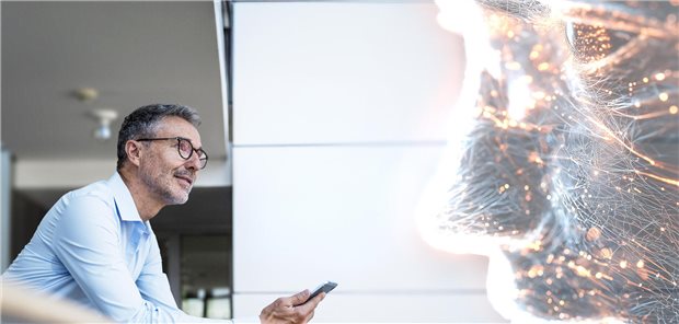 Mann mit Smartphone in der Hand spricht mit Künstlicher Intelligenz.