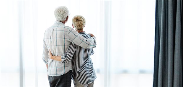 älteres Ehepaar steht am Fenster und schau hinaus