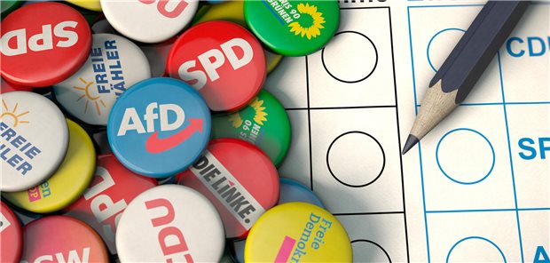 Buttons von Parteien liegen auf einem Tisch.