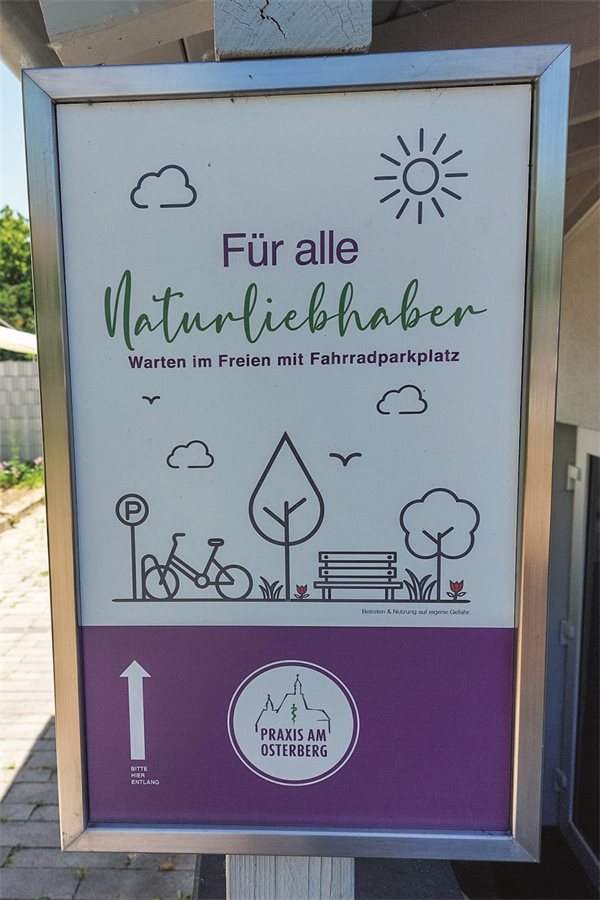 Schild, das auf den Wartebereich im Garten hinweist.