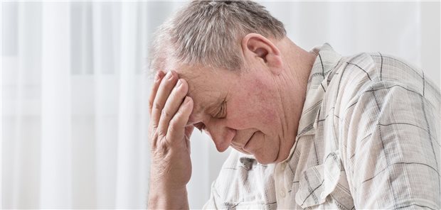 Ein älterer Herr fasst sich mit der Hand an den Kopf.