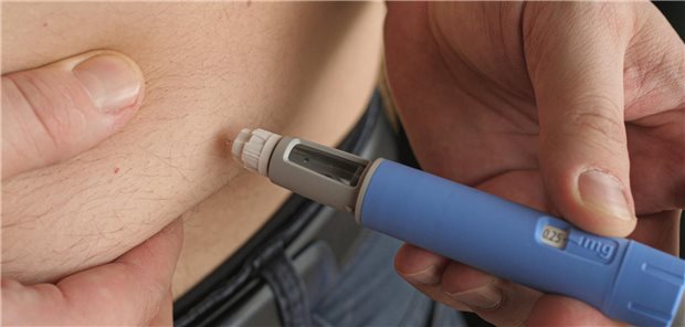 Mann spritzt sich Semaglutid in den Bauch.