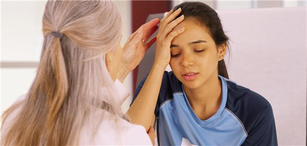 Mädchen im Trikot hält sich die Hand an den Kopf. Vor ihr eine ältere Frau. 