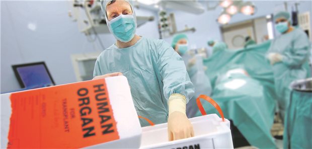 Ärzte im OP mit einer Verpackung eines menschlichen Organs.