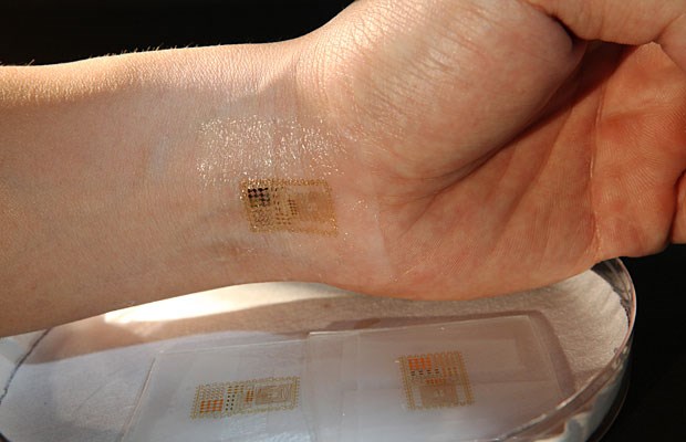 Hauchdünnes Messgerät wird auf die Haut geklebt Wie ein Tattoo wird die "elektronische Haut" zwischen zwei Schutzschichten auf die Haut gebracht und passt sich jeder Bewegung an. Bild: John A. Rogers
