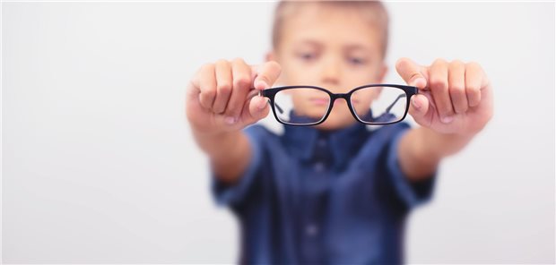 Nahaufnahme kleiner Junge mit Brille die seine Myopie korrigiert.