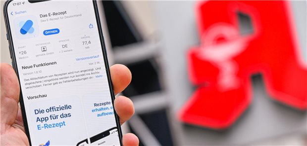 Ein Smartphone vor einer Apotheke.