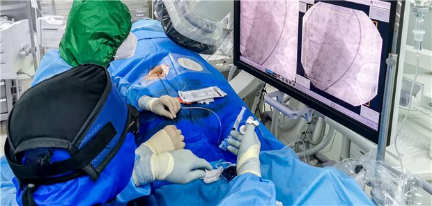 Zwei Ärzte führen bei einem Patienten eine Koronarintervention durch.