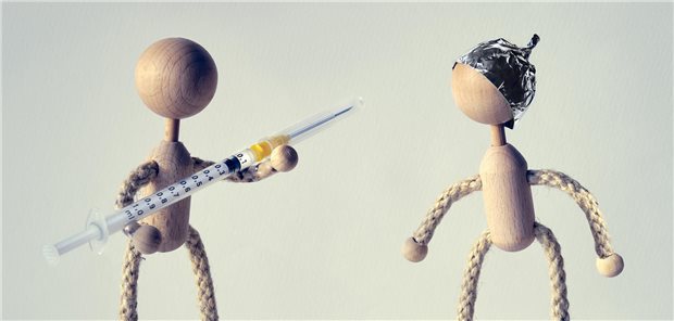 Zwei Puppen mit Spritze und Aluhut