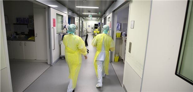 Ärzte und Pfleger laufen einen Gang entlang auf der COVID-19-Intensivstation im SRH Waldklinikum in Gera.