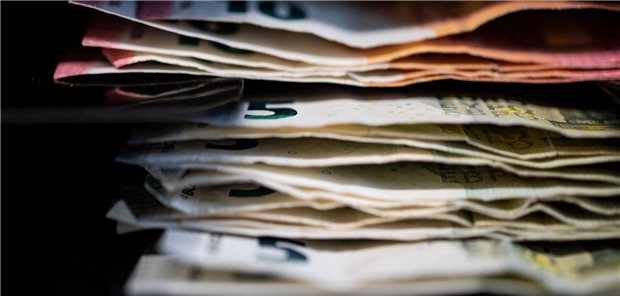 Mehrere Euro-Geldscheine liegen übereinander gestappelt.