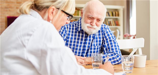 Ärztin im Gespräch mit älterem Patienten