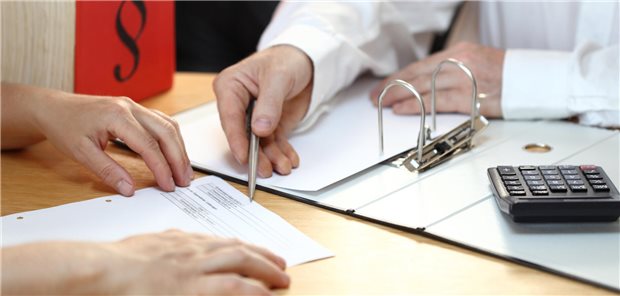 Arzt zeigt auf Dokument mit einem Stift.