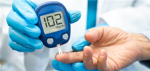Der Arzt überprüft den Blutzuckerspiegel eines Patienten, indem er für das Blutzuckermessgerät am Finger des Patienten mit einer Lanzette einen Blutstropfen aufnimmt.