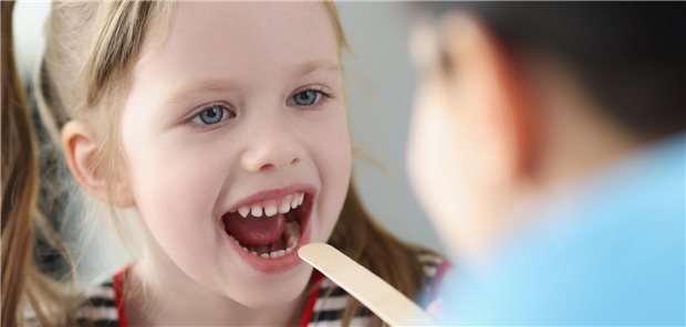 Arzt untersucht Kindermund.