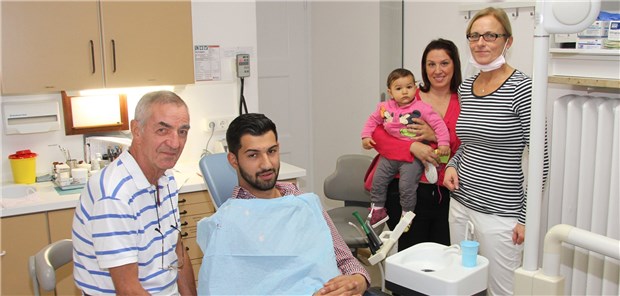 Hilfe für Patienten ohne Versicherung Zahnmedizinische Behandlung auch ohne Gesundheitskarte: Ein syrischer Familienvater (hier mit seiner Ehefrau undTochter) wird von Zahnarzt Dr. Wüst versorgt.