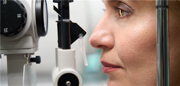 Klientin mittleren Alters, die sich einer augenärztlichen Untersuchung mit modernen Geräten unterzieht.