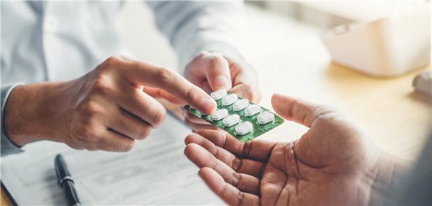 Ein Arzt empfiehlt seinem männlichem Patienten Tabletten zur Behandlung seiner Erkrankung.