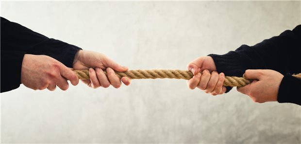 Vier Hände beim Tauziehen