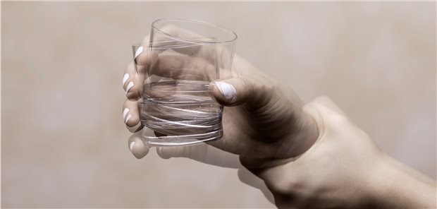 Zittern beim Halten eines Wasserglases: Parkinson kann sich durch motorische Störungen bei Patienten zeigen.