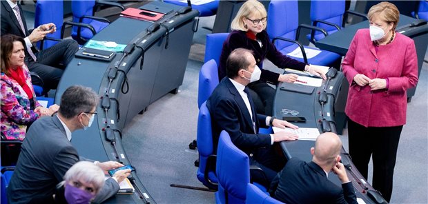 Merkel: Zweiter Corona-Lockdown ist verhältnismäßig Zu Beginn der Sitzung des Bundestags steht Bundeskanzlerin Angela Merkel mit einer Mund-Nasenbedeckung vor Abgeordneten der Fraktionen. In ihrer Regierungserklärung bezeichnet sie die Corona-Lage in Deutschland als „dramatisch“.