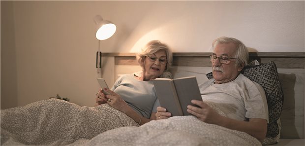 Herzinsuffizienz: Niedriger nächtlicher Blutdruck von Nachteil Blutdruckmessung eines Mannes der auf seinem Bett liegt und schläft.