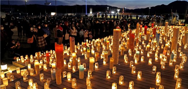 Kerzen werden in der Nähe des havarierten Kernkraftwerks Fukushima Daiichi während einer Gedenkveranstaltung für die Opfer des Erdbebens vom 11.03.2011 angezündet.