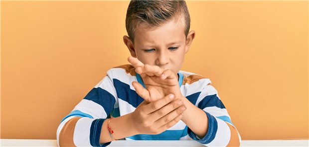 Kind hält sich die Hand