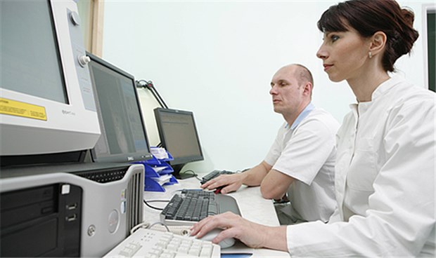 Zwei Ärzte bei gemeinsamer Arbeit am PC: Für MVZ gibt es mittlerweile Weiterentwicklungen der Praxis-Software, doch vielen Betreibern fehlen offenbar immer noch wichtige Features.