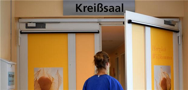 Hebamme vor dem Kreissaal.