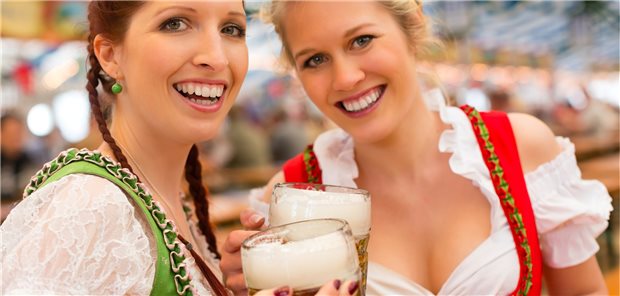 Das Oktoberfest im Gesundheits-Check Zwei Frauen im Dirndl vor einer Menschenmasse im Bierzelt: Ist das eine gesunde Umgebung?