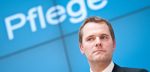 Denkzettel für Bahr Zwei Pflegekräfte helfen einer Patientin - ein seltenes Bild. Der Branche fehlen schon seit Jahren Tausende an Fachkräften.