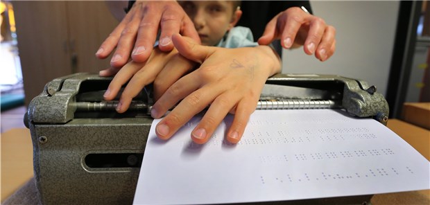 Wie Lucas seine Welt erfühlt online, 04.11.2019: Der taubblinde Lucas ertastet, unterstützt von seiner Erzieherin Stefanie Tröster, Buchstaben in Blindenschrift die er zuvor in eine Braille-Schreibmaschine getippt hatte. (Archivbild)