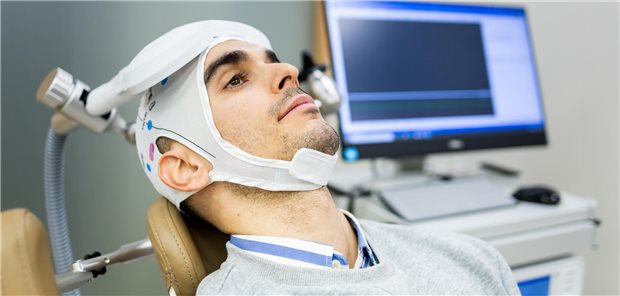 Ein Mann  unterzieht sich in einer psychiatrischen Klinik einer transkraniellen Magnetstimulationstherapie, um Depressionen oder Angstzustände zu behandeln.