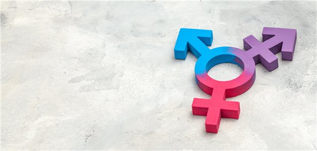 Auf einem Beton-farbenen Hintergrund liegt ein Modell des trans*-Gendersymbols 
